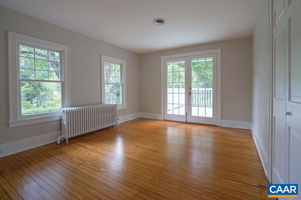 1930 Thomson Road Charlottesville, VA 22903 - Photo 17 of 35 a view of an empty room with wooden floor and a window