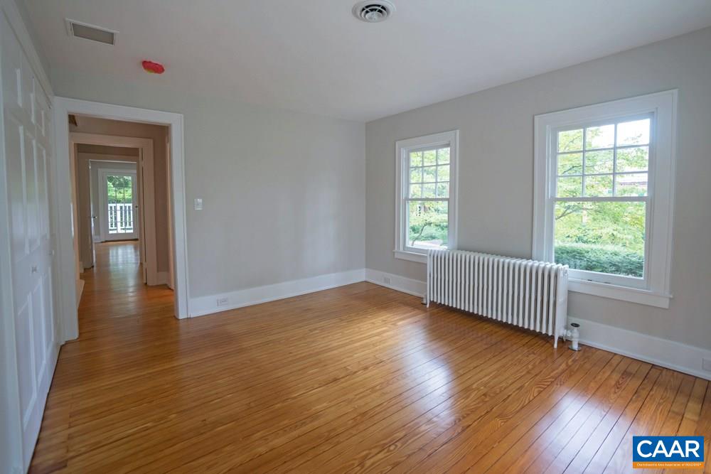 1930 Thomson Road Charlottesville, VA 22903 - Photo 22 of 35 a view of an empty room with wooden floor and a window