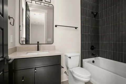 a bathroom with a bathtub shower sink vanity and toilet