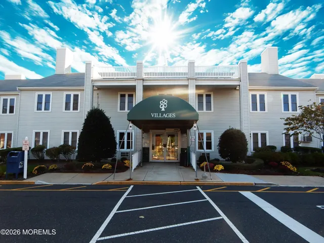 a front view of a building with cars parked
