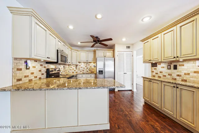 a kitchen with stainless steel appliances granite countertop a refrigerator and a sink