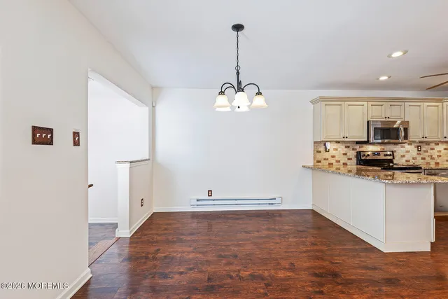 a kitchen with kitchen island granite countertop white cabinets and refrigerator