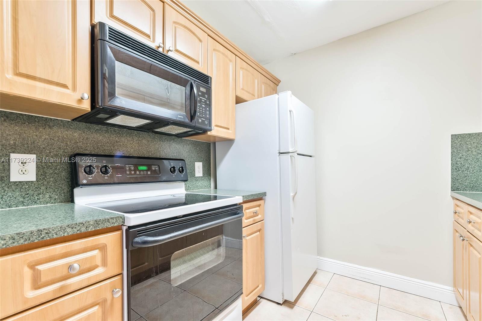 13355 Southwest 9th Court, Unit 104H Pembroke Pines, FL 33027 - Photo 11 of 22 a kitchen with stainless steel appliances granite countertop a stove a refrigerator and a microwave