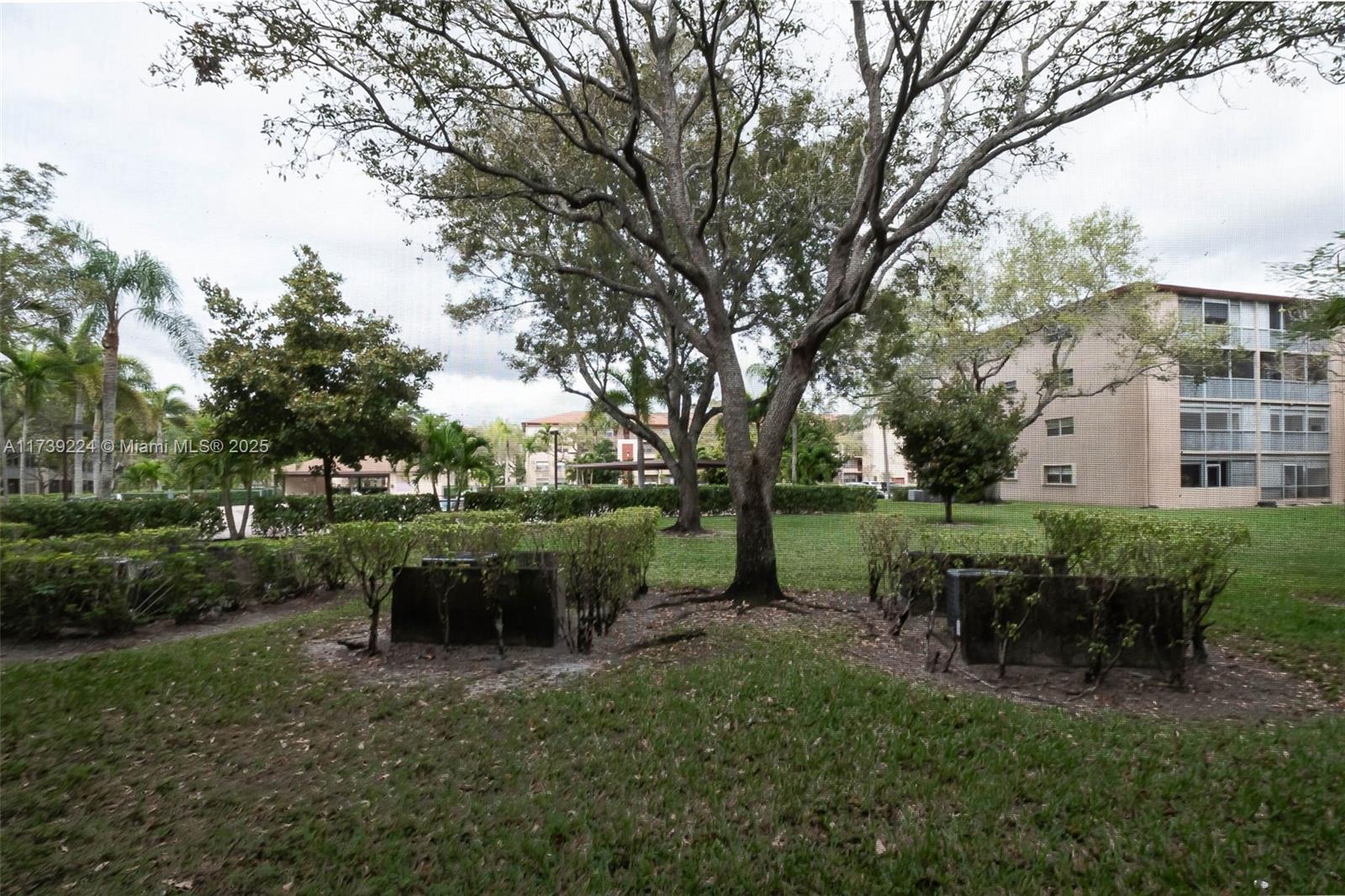 13355 Southwest 9th Court, Unit 104H Pembroke Pines, FL 33027 - Photo 18 of 22 a view of backyard with table and chairs plants and trees