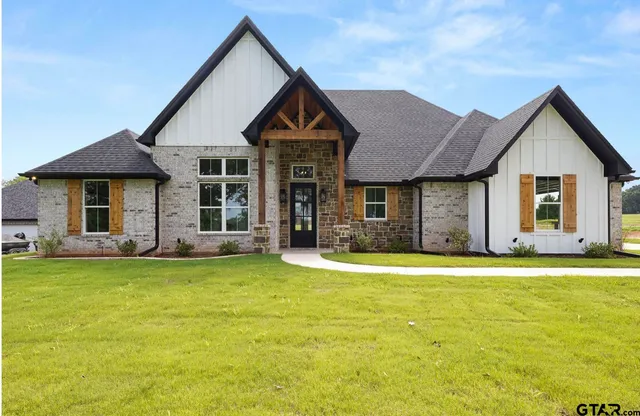 a front view of a house with a garden and yard