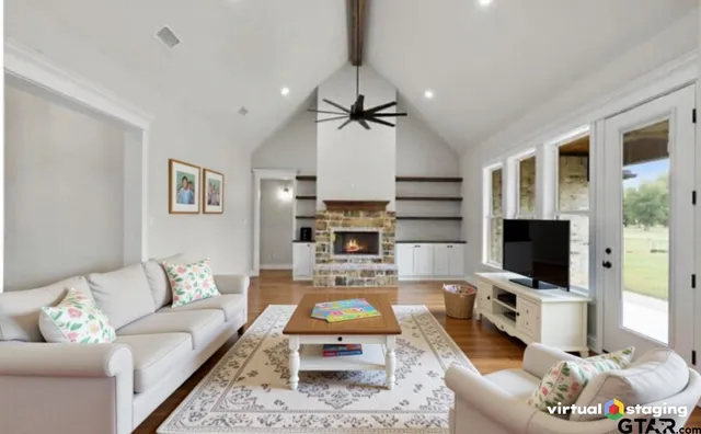 a living room with furniture a flat screen tv and a fireplace