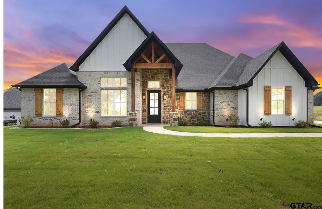 a front view of a house with a garden and yard