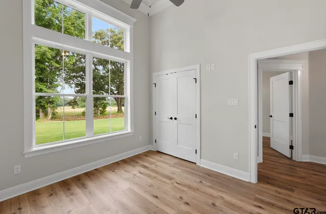 an empty room with wooden floor and windows