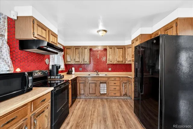 a kitchen with stainless steel appliances a stove refrigerator sink and cabinets