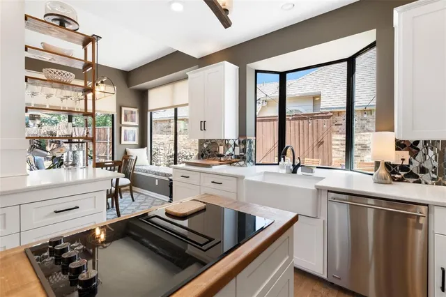 a kitchen with a sink a counter top space and living room view