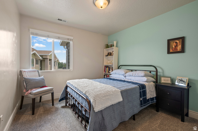 8248 South Resaca Drive, Unit J10 Sandy, UT 84070 - Photo 18 of 40 Carpeted bedroom featuring a large window, a built-in ceiling light fixture, and a built-in shelving unit