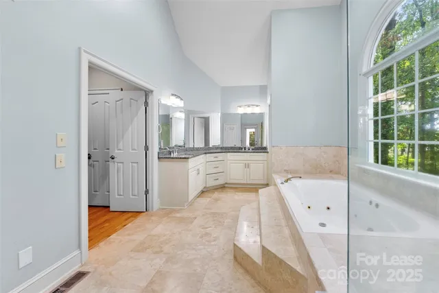 a bathroom with a tub sink and mirror