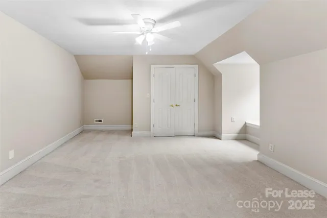 an empty room with a ceiling fan and a bathroom