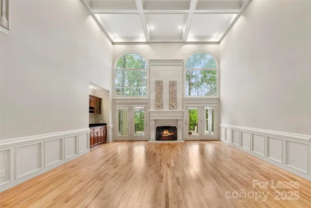 a view of empty room with fireplace and wooden floor