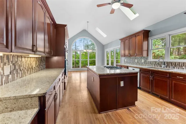 a kitchen with granite countertop a sink a counter top space and living room area