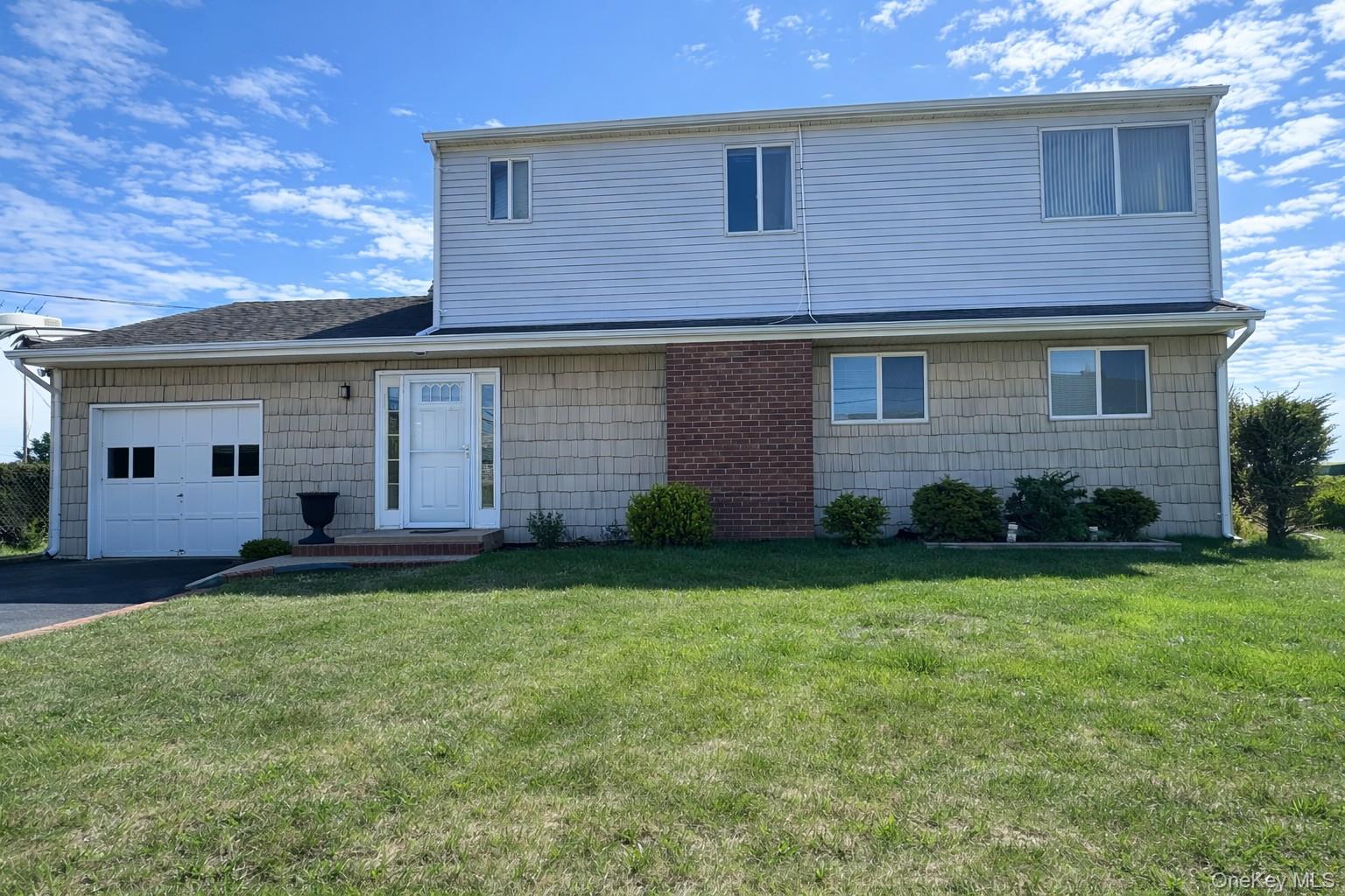 39 Barracuda Road East Quogue, NY 11942 - Photo 1 of 15 a front view of house with yard and outdoor seating