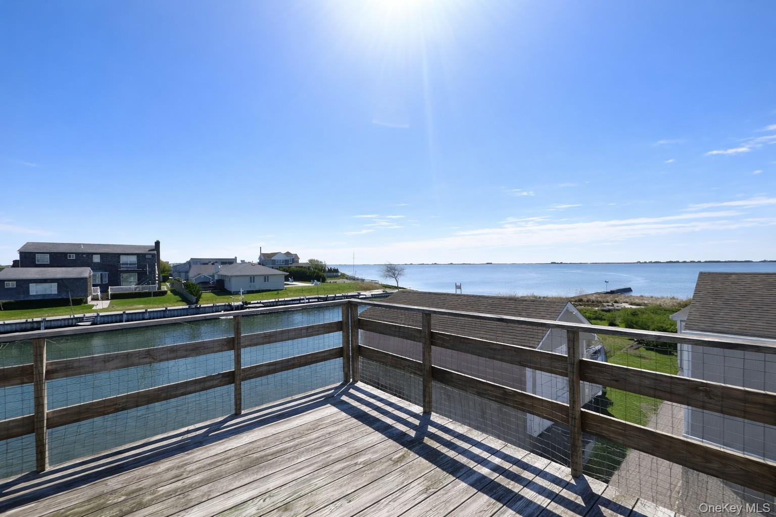 39 Barracuda Road East Quogue, NY 11942 - Photo 2 of 15 a view of a balcony with wooden floor and city view