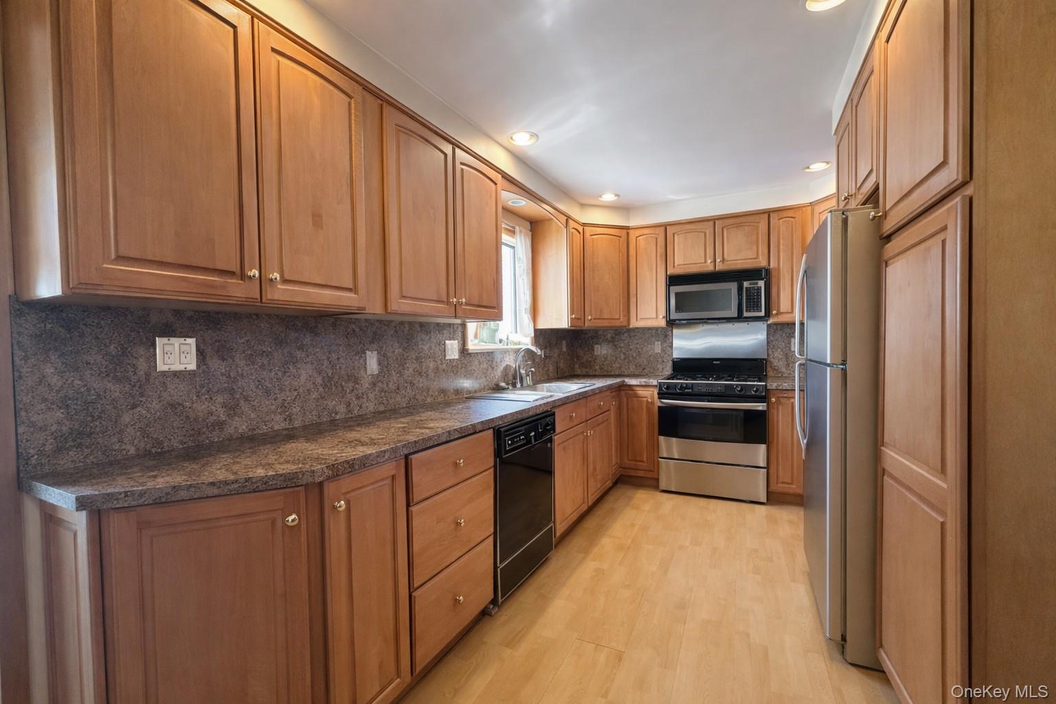 39 Barracuda Road East Quogue, NY 11942 - Photo 5 of 15 a kitchen with stainless steel appliances granite countertop a refrigerator sink and cabinets