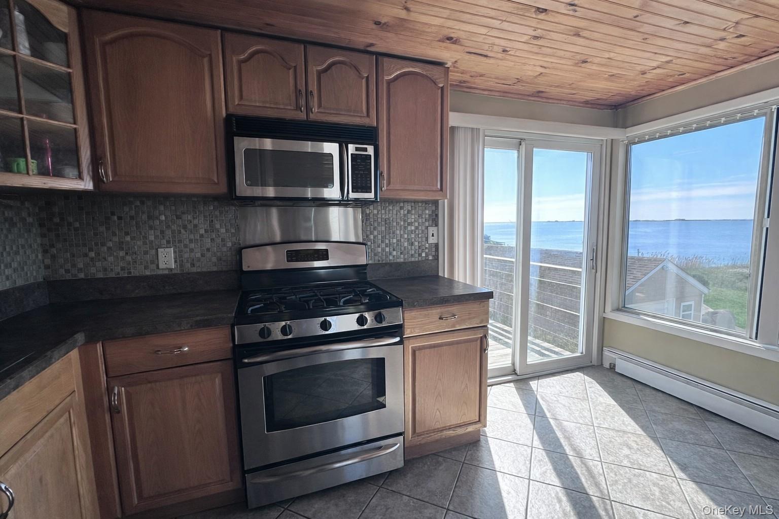 39 Barracuda Road East Quogue, NY 11942 - Photo 9 of 15 a kitchen with granite countertop a stove and a microwave