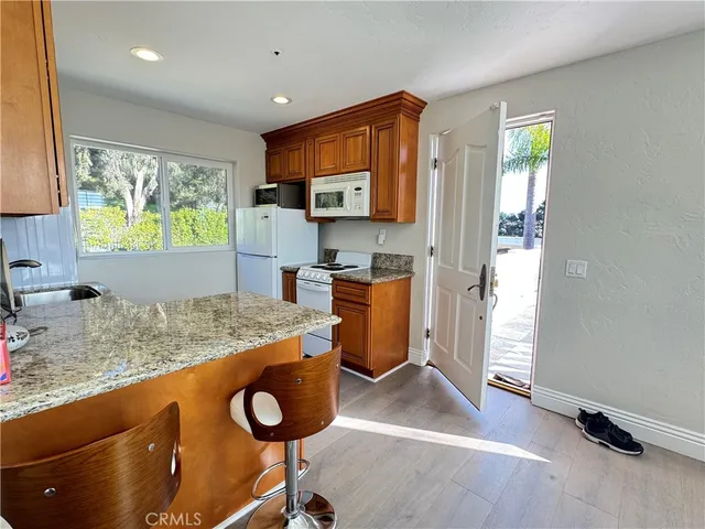 a kitchen with granite countertop a stove and a wooden floor