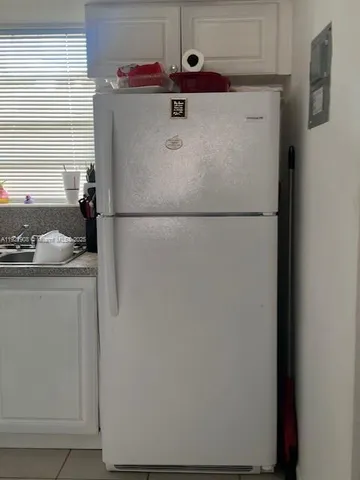 a white refrigerator freezer sitting inside of a kitchen