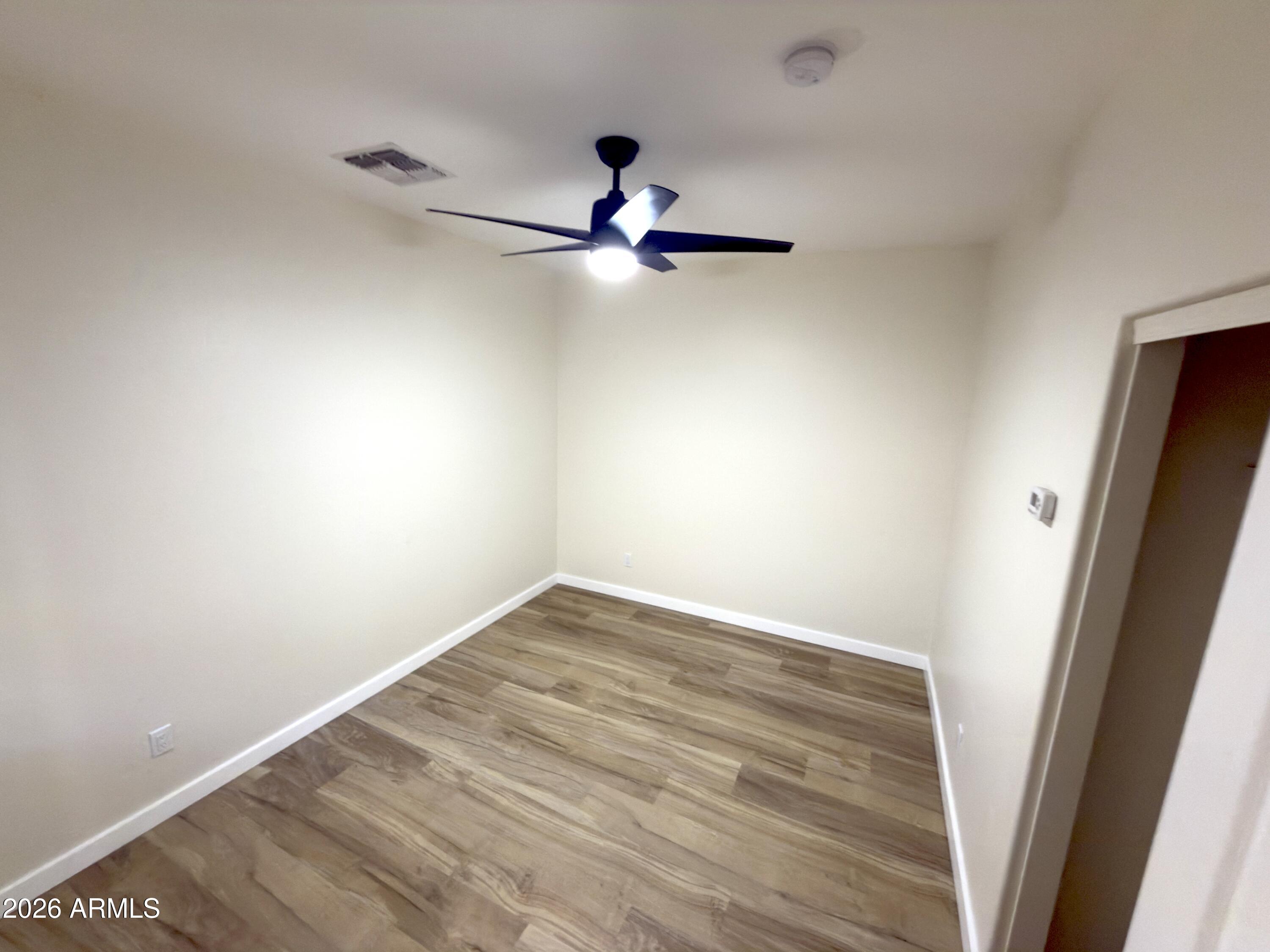 5319 West Coles Road Laveen, AZ 85339 - Photo 16 of 20 a view of empty room with wooden floor