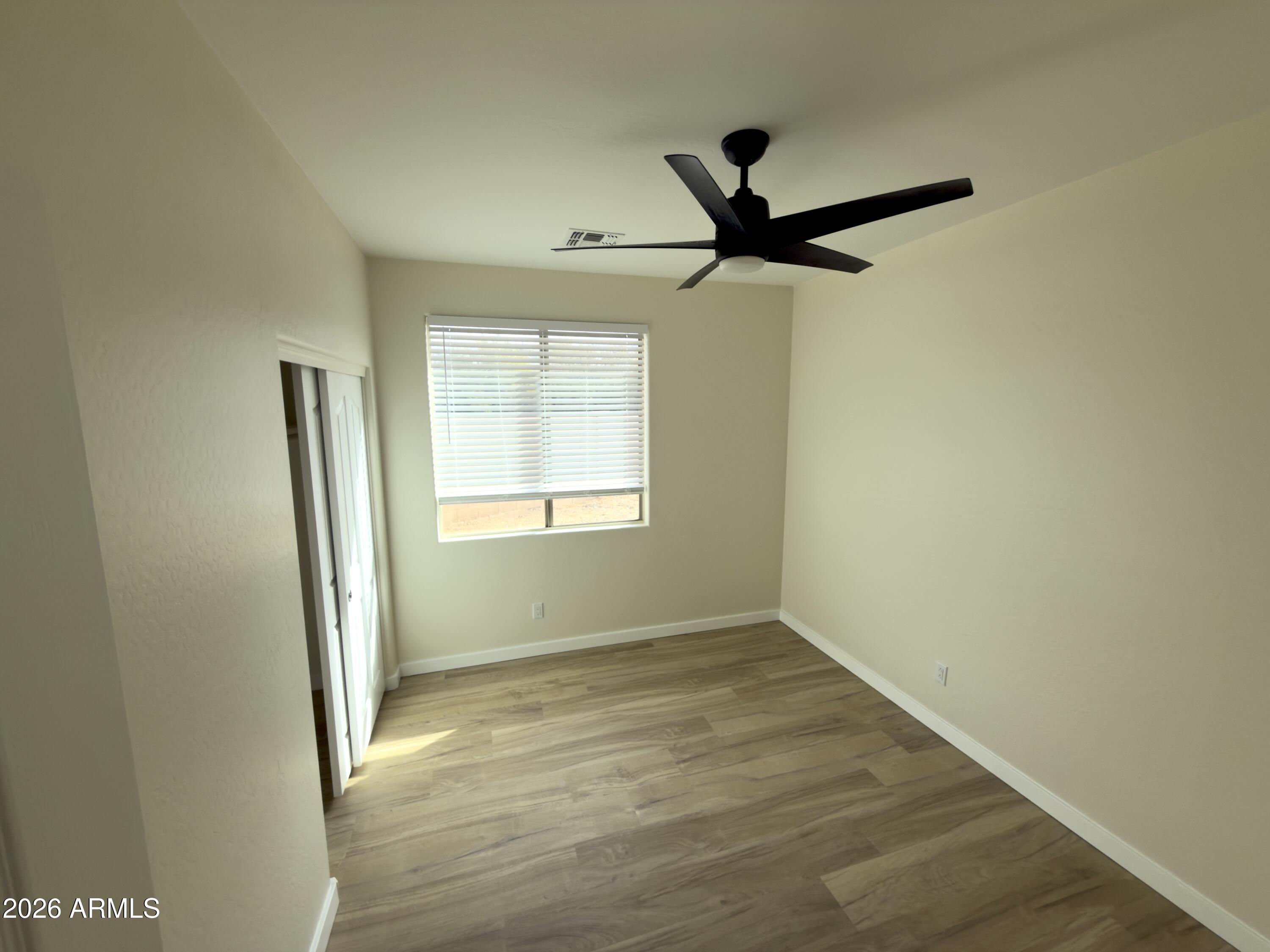 5319 West Coles Road Laveen, AZ 85339 - Photo 19 of 20 a view of empty room with wooden floor and fan