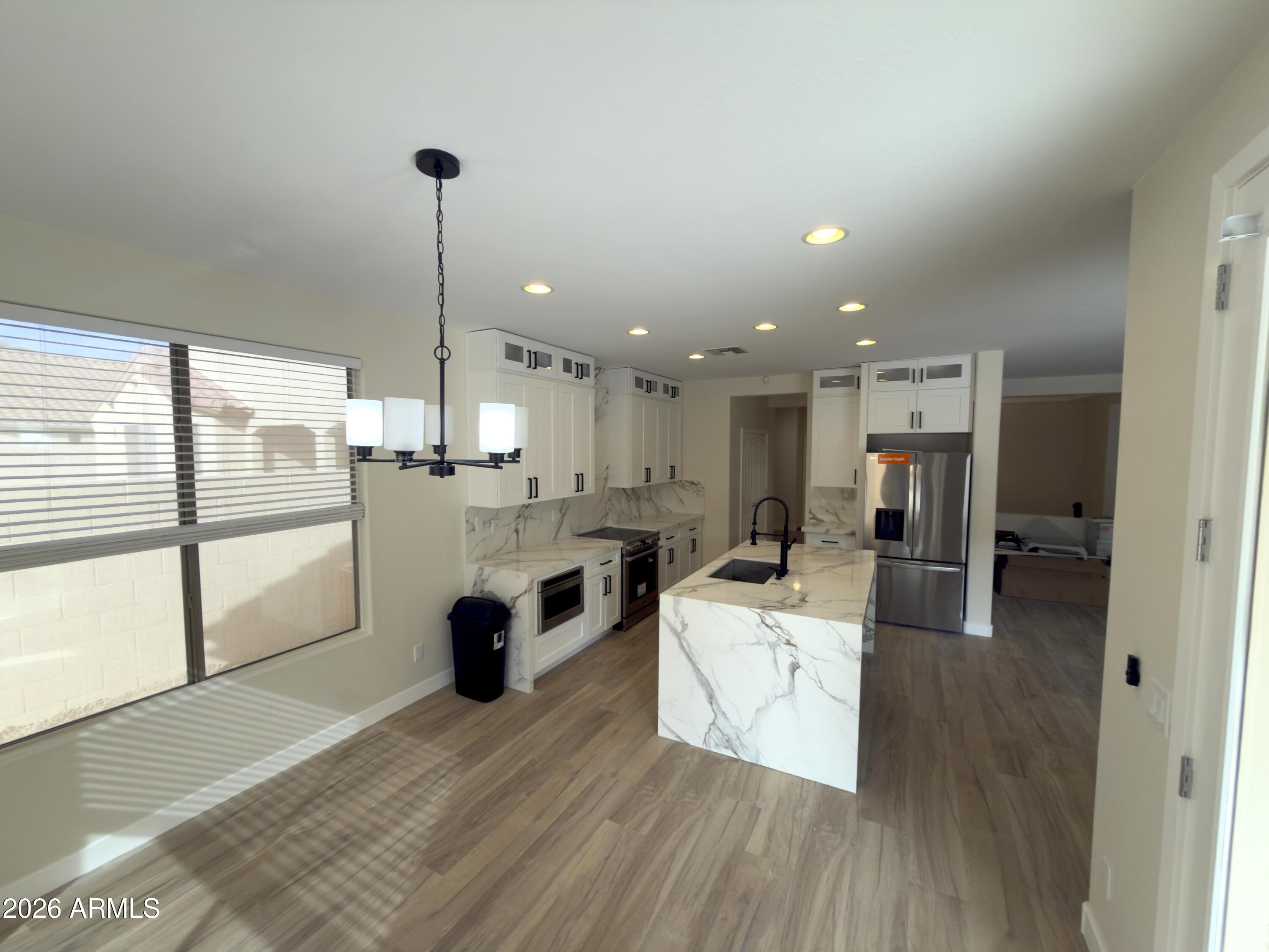 5319 West Coles Road Laveen, AZ 85339 - Photo 3 of 20 a open kitchen with white cabinets and stainless steel appliances