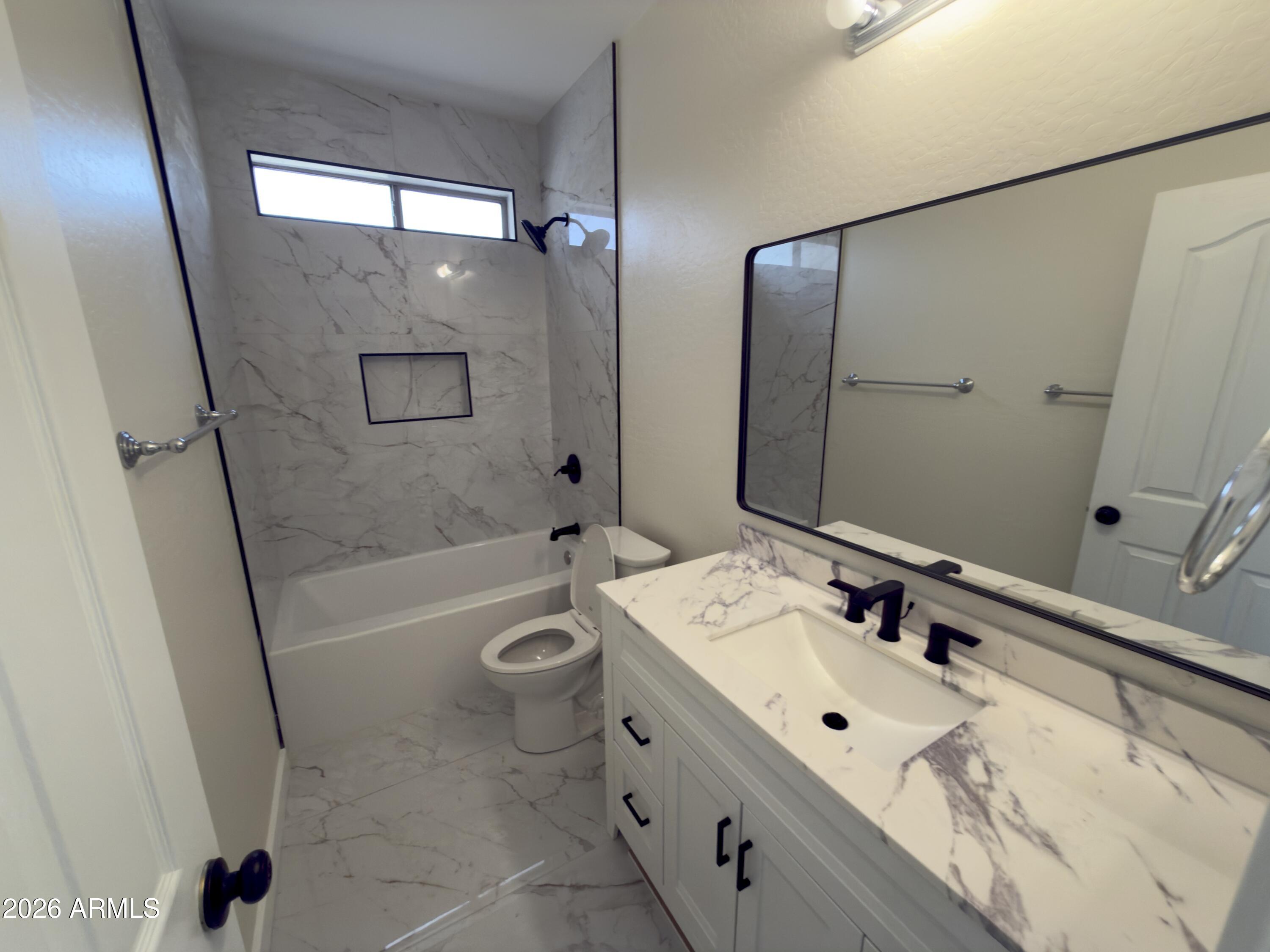 5319 West Coles Road Laveen, AZ 85339 - Photo 7 of 20 a bathroom with a tub sink and mirror