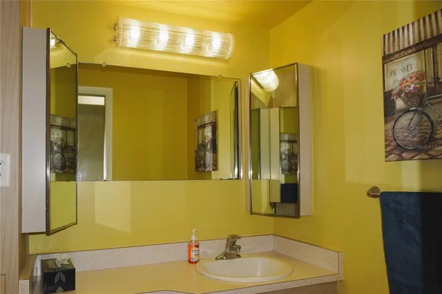 a view of a hallway with wooden floor and a bathroom