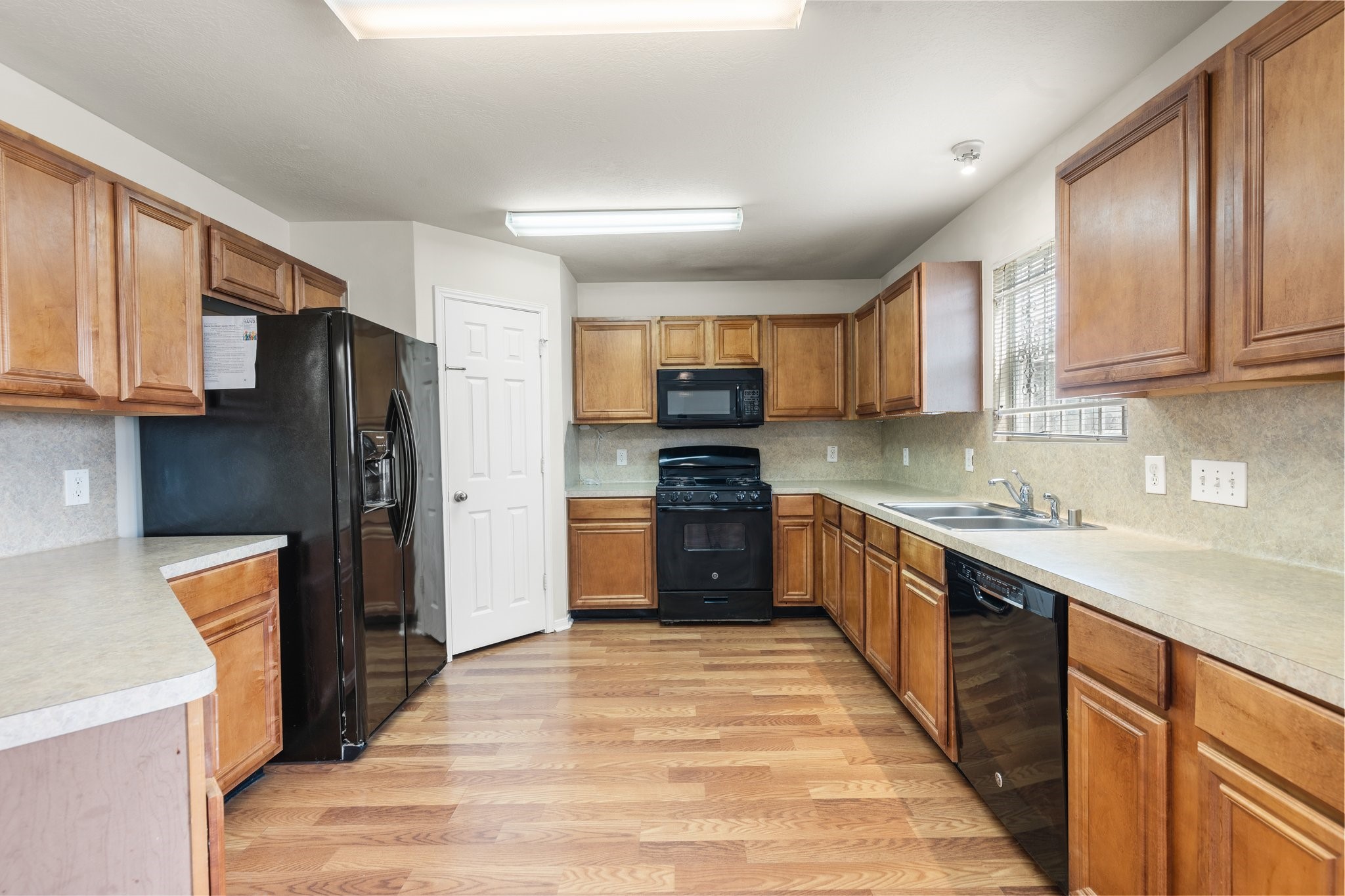 3111 Holly Ranch Drive Katy, TX 77494 - Photo 9 of 28 a kitchen with granite countertop wooden cabinets a refrigerator a stove a sink and dishwasher with wooden floor