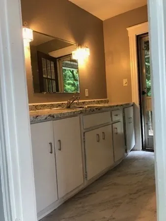 a bathroom with a granite countertop sink and a mirror