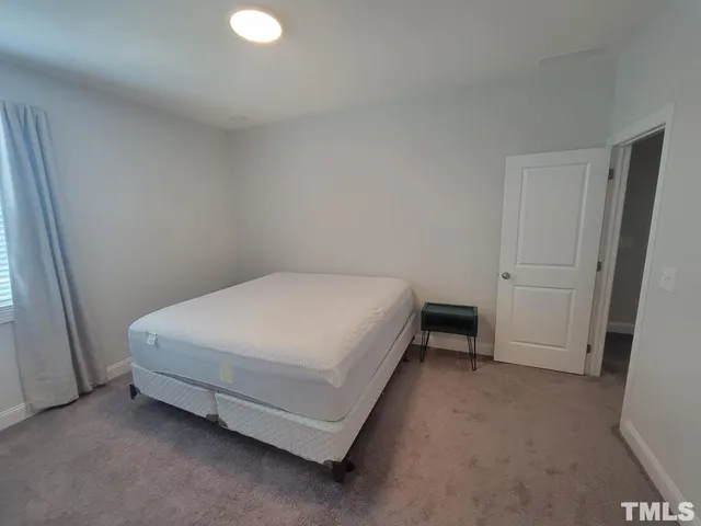 a bed sitting in a room next to a window