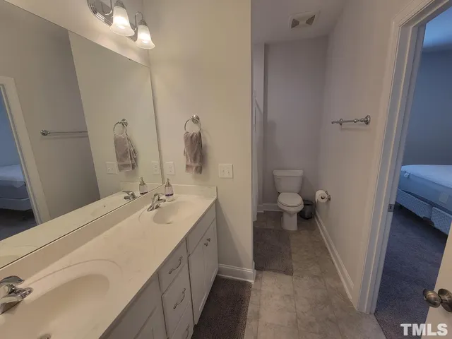a en suite bathroom with a double vanity sink and a mirror