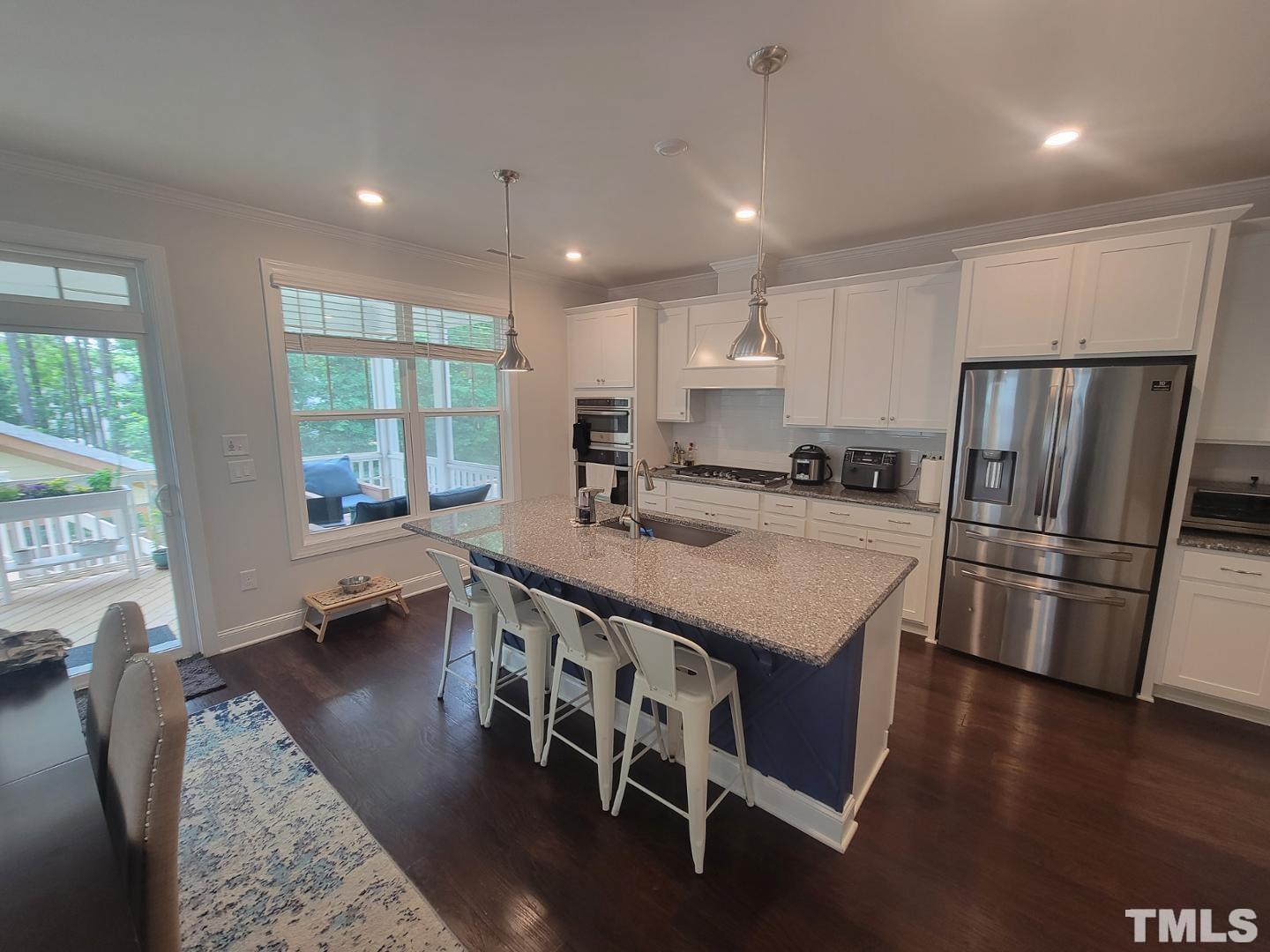 105 Winding Creek Loop Chapel Hill, NC 27517 - Photo 40 of 47 a kitchen with stainless steel appliances granite countertop a stove a refrigerator a sink a dining table and chairs