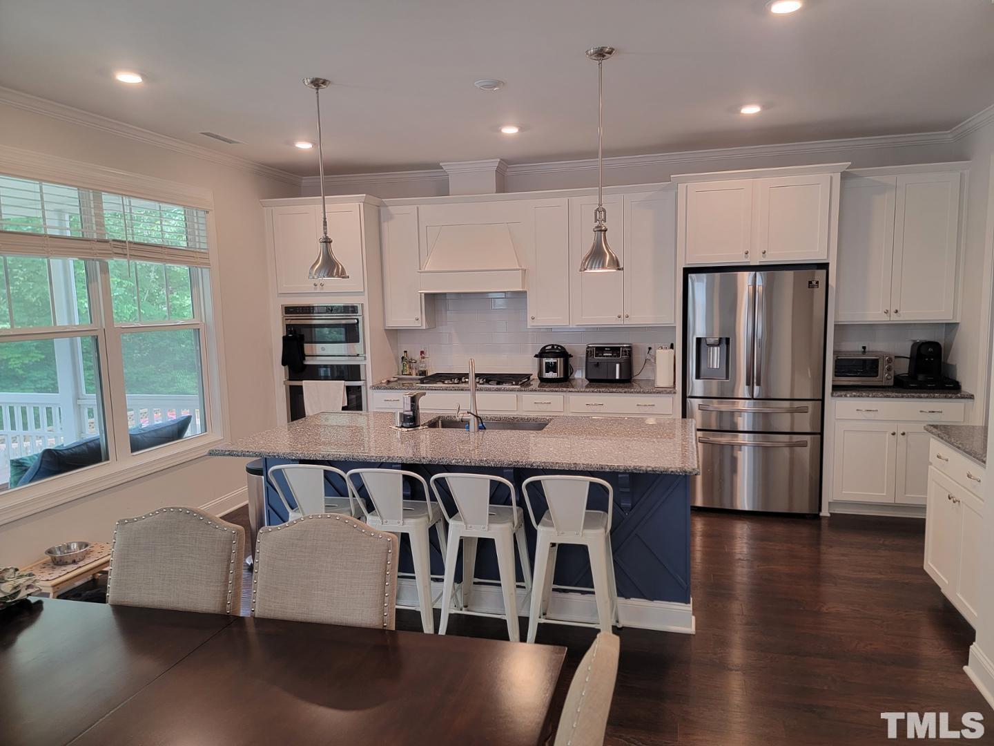 105 Winding Creek Loop Chapel Hill, NC 27517 - Photo 4 of 47 a kitchen with stainless steel appliances granite countertop a refrigerator a sink dishwasher a stove and white cabinets with wooden floor