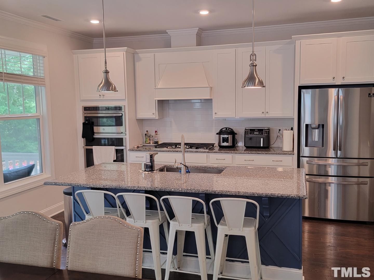 105 Winding Creek Loop Chapel Hill, NC 27517 - Photo 5 of 47 a kitchen with granite countertop a refrigerator a stove a sink and white cabinets with wooden floor