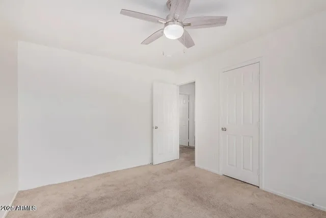 an empty room with chandelier fan
