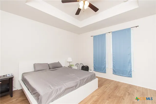 a bedroom with a large bed and a chandelier