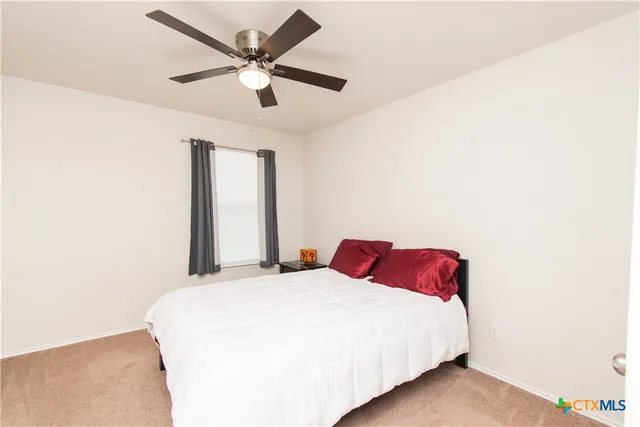 a bedroom with a bed and a ceiling fan