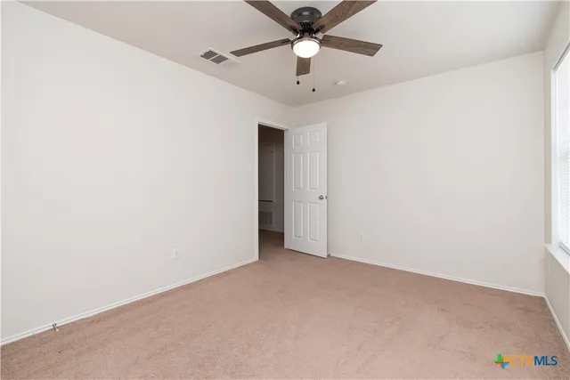 an empty room with a ceiling fan and a fan