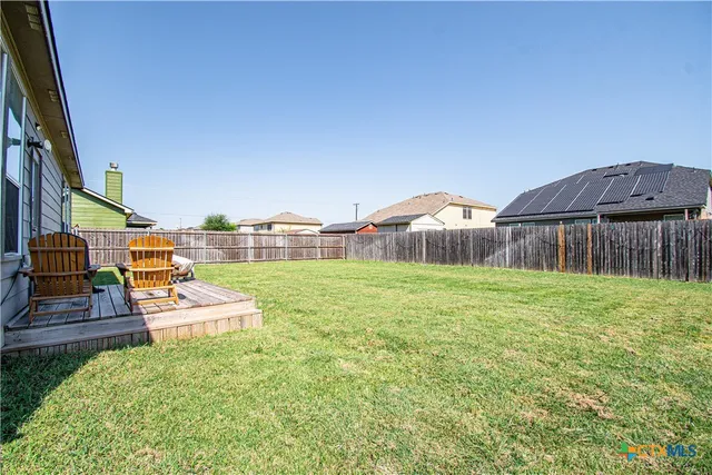 a backyard of a house with table and chairs
