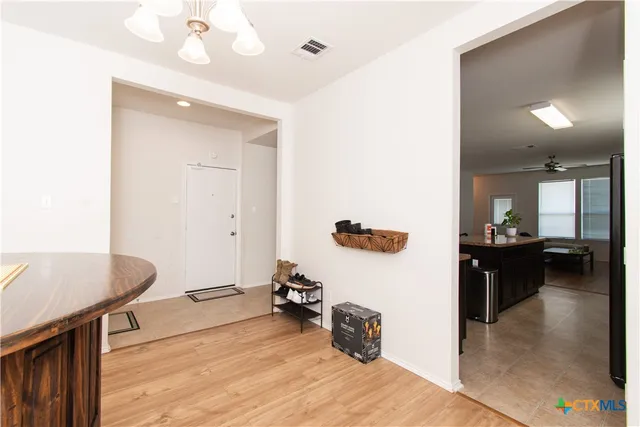 a view of dining room with kitchen island stainless steel appliances wooden floor and living room view