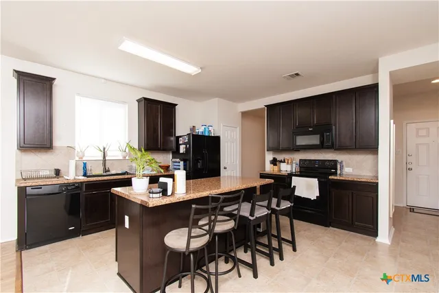 a kitchen with stainless steel appliances kitchen island granite countertop a sink and cabinets