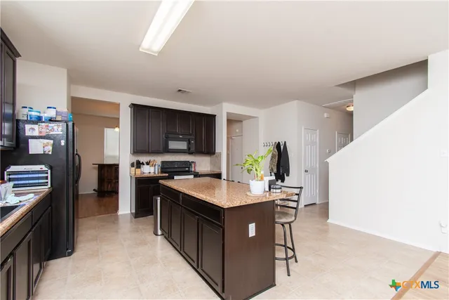 a kitchen with a stove top oven a sink a counter top space and cabinets