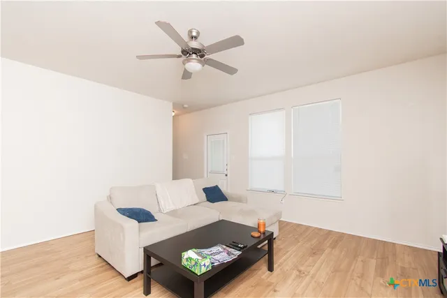 a living room with furniture and a wooden floor