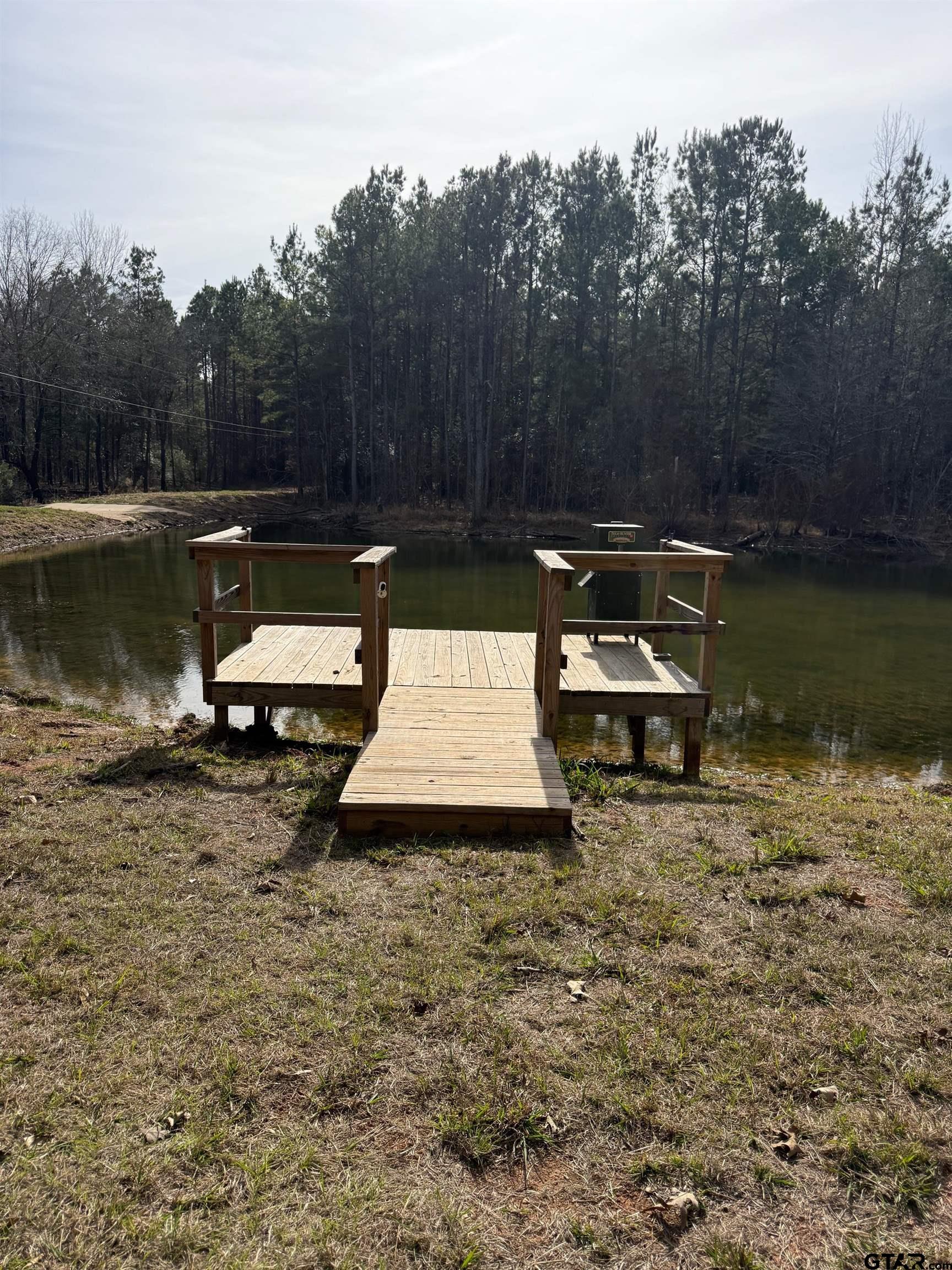 748 County Road Rusk, TX 75785 - Photo 29 of 40 a view of a lake with a bench and trees