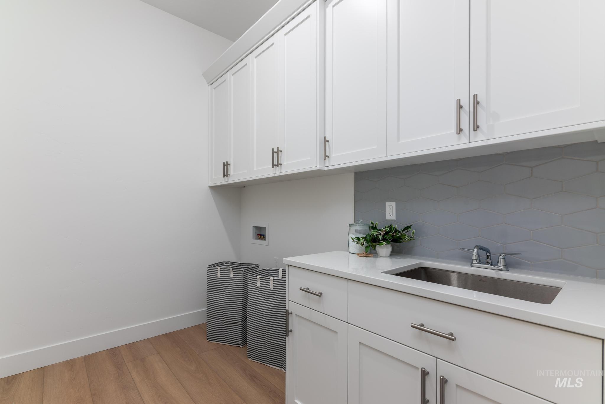 9074 West Moonglade Street Star, ID 83669 - Photo 27 of 40 Functional utility space featuring white shaker cabinetry, an undermount sink, and a light-toned countertop