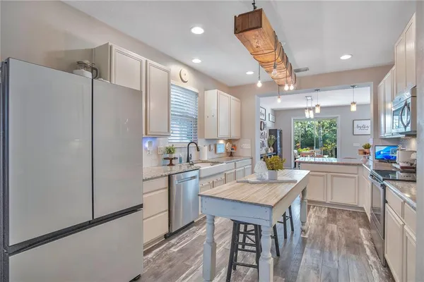 a kitchen with granite countertop a sink stove and refrigerator