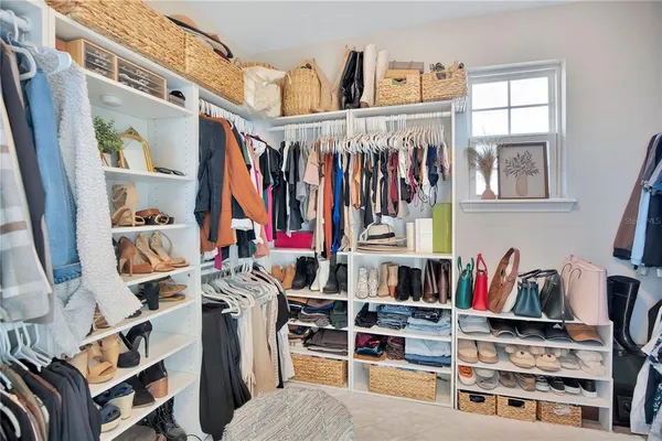 a view of walk in closet with clothes and shoes